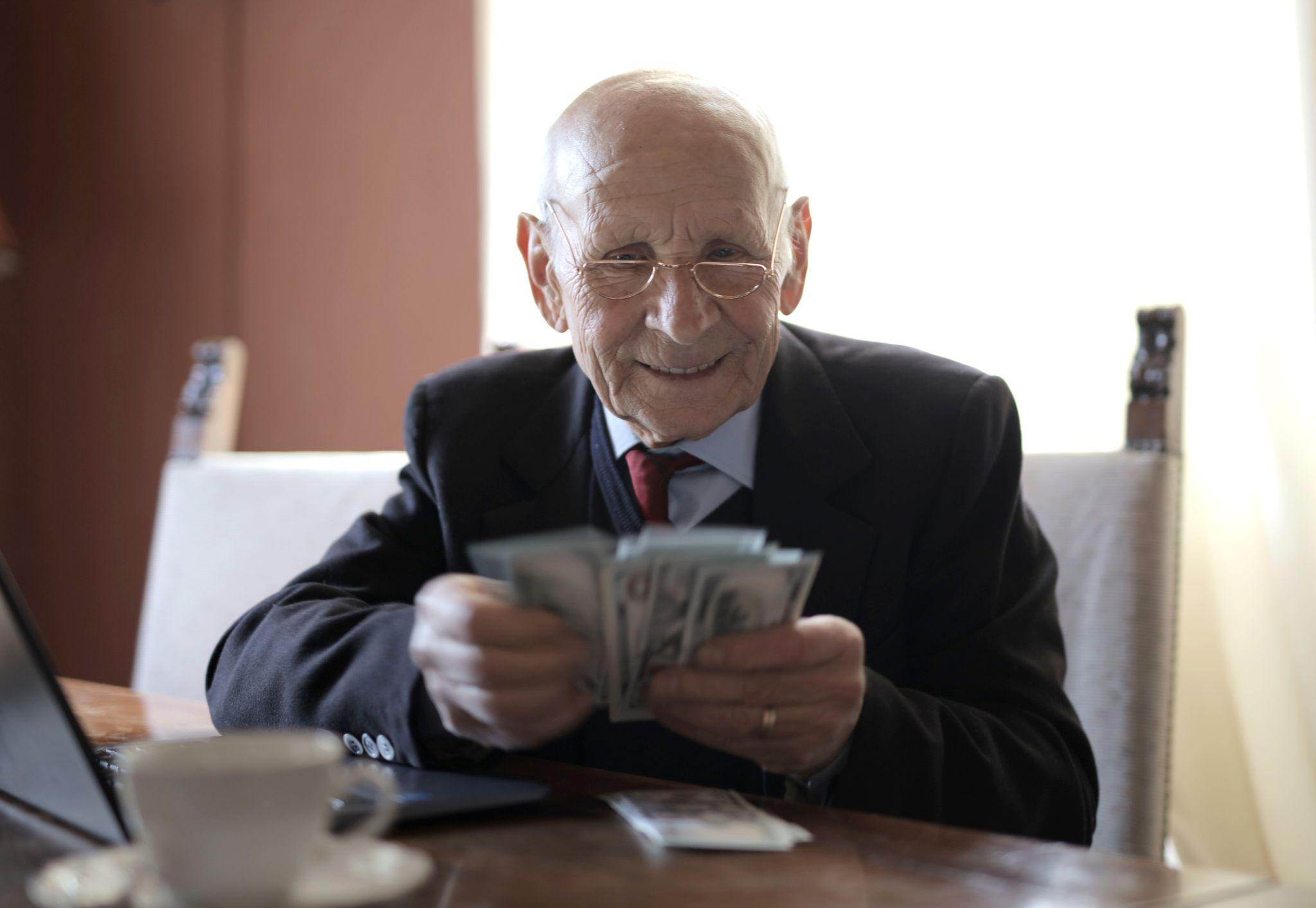 An older adult counting his pension income