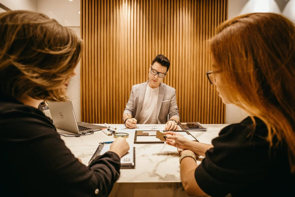 An image of two women and a man during a meeting in the office